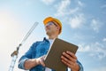 Builder in hardhat with tablet pc at construction Royalty Free Stock Photo