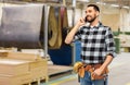 Builder in helmet calling on smartphone