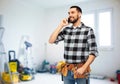 Builder in helmet calling on smartphone