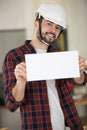 Builder in helmet showing blank banner