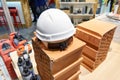 Builder helmet, tools and bricks in store