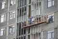 Builder works in a special suspended platform at high altitude