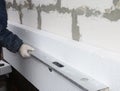 Builder holding spirit level in hand on the rigid styrofoam insulation wall. Rigid extruded polystyrene insulation concept Royalty Free Stock Photo