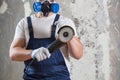 The builder holds in hands Angle grinder. Repair work, interior decoration of walls Royalty Free Stock Photo