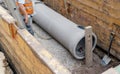 Builder installing big diameter concrete drainage pipe protected by trench support system during deep drainage works Royalty Free Stock Photo