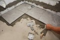 Builder installing ceramic tile on the floor, bathroom flooring. Floor tiling