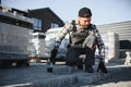 Builder laying a paving brick placing it on the sand foundation with gloved hands Royalty Free Stock Photo