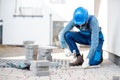 Builder laying paving tiles