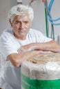 Builder leaning on roll insulating material