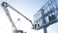 Builder on a Lift Platform at a construction site. Men at work. construction worker assembling scaffold on building site Royalty Free Stock Photo