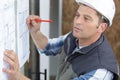 builder looking and hand writting on plan Royalty Free Stock Photo