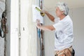 Builder looking at plans holding tape measure