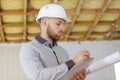 Builder making notes on clipboard