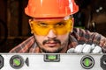 Builder man looks at the construction level checks the horizontal surface, male hands with a level close-up. Construction work, Royalty Free Stock Photo