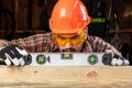 Builder man looks at the construction level checks the horizontal surface, male hands with a level close-up. Construction work, Royalty Free Stock Photo