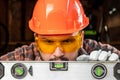 Builder man looks at the construction level checks the horizontal surface, male hands with a level close-up. Construction work, Royalty Free Stock Photo