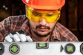 Builder man looks at the construction level checks the horizontal surface, male hands with a level close-up. Construction work, Royalty Free Stock Photo