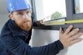 builder measuring window using retractable tape measure Royalty Free Stock Photo