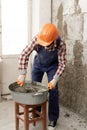 builder mixing mortar to install bricks block on construction site, repair house concept. Royalty Free Stock Photo