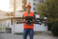 Builder operating drone with remote control at construction site focus on quadcopter. Aerial survey