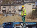 Builder in overalls at the construction site. Repairs at altitude. Construction of new buildings. The profession of a builder. Hea