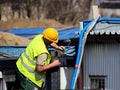 Builder in overalls at the construction site. Repairs at altitude. Construction of new buildings. The profession of a builder. Hea