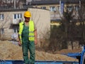 Builder in overalls at the construction site. Repairs at altitude. Construction of new buildings. The profession of a builder. Hea