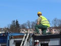 Builder in overalls at the construction site. Repairs at altitude. Construction of new buildings. The profession of a builder. Hea