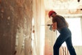 Builder with perforator drills holes in concrete wall Royalty Free Stock Photo