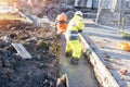 Builder pouring wall foundation with wet ready-mix concrete, levelling it and checking the level