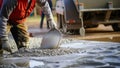 Builder pours ready mix concrete from a cement mixer truck at a construction site Royalty Free Stock Photo