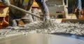 Builder pours ready mix concrete from a cement mixer truck at a construction site Royalty Free Stock Photo