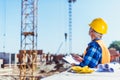 builder in reflective vest and hardhat standing at construction site with clipboard Royalty Free Stock Photo