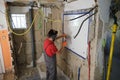 Builder removing a mirror from a wall with a hammer.