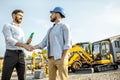 Builder with a sales consultant at the shop with heavy machinery Royalty Free Stock Photo