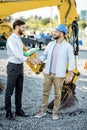 Builder with a sales consultant at the shop with heavy machinery Royalty Free Stock Photo