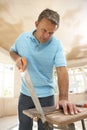 Builder Sawing Wood On Workbench