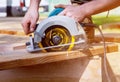 Builder saws a board with a circular saw cutting a wooden plank Royalty Free Stock Photo
