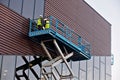 Builder on a Scissor Lift Platform at a construction site Royalty Free Stock Photo