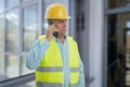 Builder with serious expression talking on smart telephone