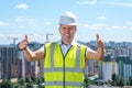Builder showing thumbs up with two hands on the roof
