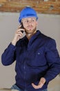 builder shrugging while talking on smartphone Royalty Free Stock Photo