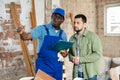 Builder signs documents from the engineer, pointing him to something Royalty Free Stock Photo