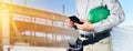 Builder with tools and hard hat holds smartphone in his hands Royalty Free Stock Photo