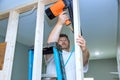 Builder uses an air hammer to attach wooden beams to a house support framework