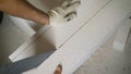 The builder uses a saw for concrete blocks. A worker cuts a block with a hand saw.