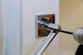 Builder using an drill screwdriver in installing door lock in house