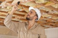 builder using smartphone to photograph ceiling joists