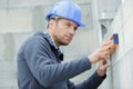 builder using spirit level against block wall Royalty Free Stock Photo