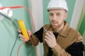 Builder using yellow multimeter to calibrate house